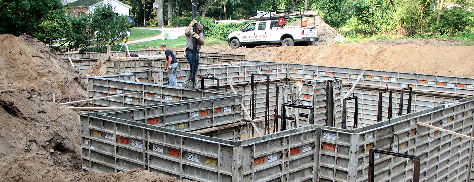 Crew pours concrete into forms for basement/foundation
